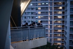 Polisi berpatroli di area kompleks perumahan umum Kwai Chung Estate di Hong Kong yang di-lockdown di tengah menrebaknya varian omicron COVID-19, 22 Januari 2022. (Louise Delmotte/AFP)