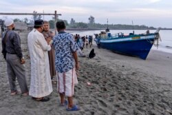 Penduduk setempat memeriksa kapal yang membawa ratusan etnis Rohingya yang mendarat di pantai di Lhokseumawe, provinsi Aceh, Senin, 7 September 2020.