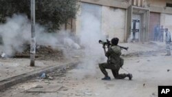 FILE - A Libyan military soldier fires his weapon during clashes with Islamic extremist militias in Benghazi, Libya, Oct. 30, 2014. 