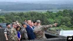 Le président Donald Trump regarde la Corée du Nord depuis la zone démilitarisée au poste d'observation Ouellette au Camp Bonifas en Corée du Sud, le dimanche 30 juin 2019 avec le président sud-coréen Moon Jae-in. (Photo AP / Susan Walsh)