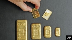 A one-ounce gold bar [top R] designed by fashion designer Jean Paul Gaultier is displayed with gold bars weighing between one ounce and 500 grams in an office of French gold supplier CPoR Devises company in Paris, October 10, 2011.