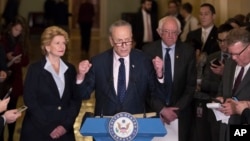 Senate Minority Leader Charles Schumer of New York, flanked by Sen. Debbie Stabenow, D-Mich., left, and Sen. Bernie Sanders, I-Vt., critiques policies of President Donald Trump during a news conference on Capitol Hill in Washington, Jan. 24, 2017.