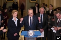 FILE - Senate Minority Leader Charles Schumer of New York, flanked by Sen. Debbie Stabenow, D-Mich., left, and Sen. Bernie Sanders, I-Vt., critiques policies of President Donald Trump during a news conference on Capitol Hill in Washington, Jan. 24, 2017.
