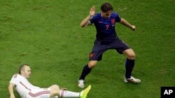 Spain's Andres Iniesta tries to reach the ball against Netherlands' Daryl Janmaat during the group B World Cup soccer match between Spain and the Netherlands at the Arena Ponte Nova in Salvador, Brazil, June 13, 2014.