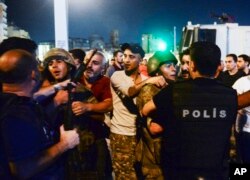 Turkish soldiers, arrested by civilians after an attempted coup, are handed to police officers in Istanbul on July 16, 2016.