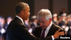 Presiden Amerika Serikat Barack Obama (kiri) dan Menhan AS Chuck Hagel dalam upacara perpisahan di Pangkalan Militer Myer-Henderson Hall di Virginia (28/1).