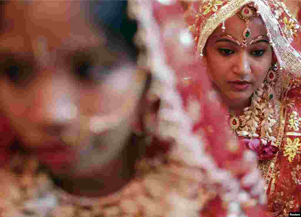 Brides wait for the start of a mass wedding ceremony in the old quarters of Delhi, India. A total of 12 couples took their wedding vows on Friday during the ceremony organized by a Hindu religious organization.