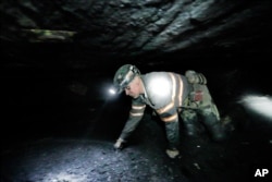 FILE - Coal miner Scott Tiller crawls through an underground coal mine roughly 40 inches high, May 11, 2016, in Welch, W.V. (AP Photo/David Goldman)