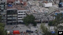 Petugas penyelamat mencari orang-orang yang terjebak di dalam gedung yang runtuh di kawasan Roma Norte, Mexico City, Rabu, 20 September 2017. (AP Photo/Rebecca Blackwell)