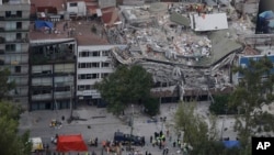 Petugas penyelamat mencari orang-orang yang terjebak di dalam gedung yang runtuh di kawasan Roma Norte, Mexico City, Rabu, 20 September 2017. (AP Photo/Rebecca Blackwell)