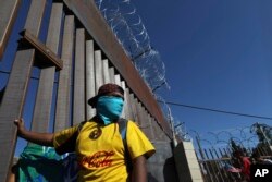 Migrants gather at the Mexico-U.S. border after getting past a line of Mexican police at the Chaparral crossing in Tijuana, Nov. 25, 2018, as they try to reach the U.S.