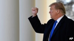 President Donald Trump gestures to the audience as he heads to the Oval Office after declaring a national emergency in order to build a wall along the southern border, Feb. 15, 2019, at the White House in Washington.