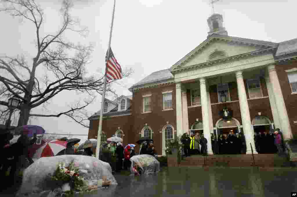 Officials including Connecticut Governor Dan Malloy observe a moment of silence on the steps of Edmond Town Hall while bells ring 26 times in Newtown, Connecticut, December 21, 2012. 