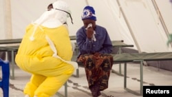 A health worker wearing protective gear attends to a newly admitted suspected Ebola patient in a quarantine zone at a Red Cross facility in the town of Koidu, Kono district in Eastern Sierra Leone, Dec. 19, 2014. 