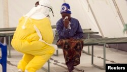 A health worker wearing protective gear attends to a newly admitted suspected Ebola patient in a quarantine zone at a Red Cross facility in the town of Koidu, Kono district in Eastern Sierra Leone, Dec. 19, 2014. 