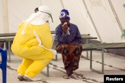 在塞拉利昂的医护人员穿着防护服检查疑似埃博拉患者的病情