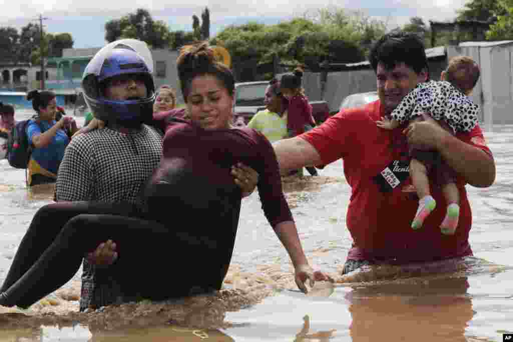 A pregnant woman is carried out of an area flooded by water brought by Hurricane Eta in Planeta, Honduras, Thursday, Nov. 5, 2020. The storm that hit Nicaragua as a Category 4 hurricane on Tuesday had become more of a vast tropical rainstorm, but it was a