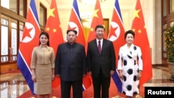 Pemimpin Korea Utara Kim Jong-un dan istrinya Ri Sol Ju, berfoto bersama Presiden China, Xi Jinping dan istri Peng Liyuan, di Balai Besar Rakyat di Beijing, China, 28 Maret 2018. (Foto: Ju Peng/Xinhua via REUTERS).