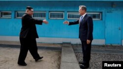 지난해 4월 27일 남북한 정상회담 당시 문재인 한국 대통령과 김정은 북한 국무위원장이 판문점 군사분계선을 넘어 처음 만나고 있다.