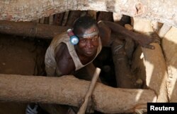 An artisanal gold miner emerges from a pit at an unlicensed mine near the city of Bouna, Ivory Coast, Feb. 11, 2018.