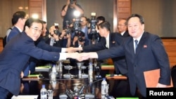 South Korean Unification Minister Cho Myoung-gyon shakes hands with his North Korean counterpart Ri Son Gwon after their meeting at the truce village of Panmunjom inside the demilitarized zone, North Korea, Aug. 13, 2018.