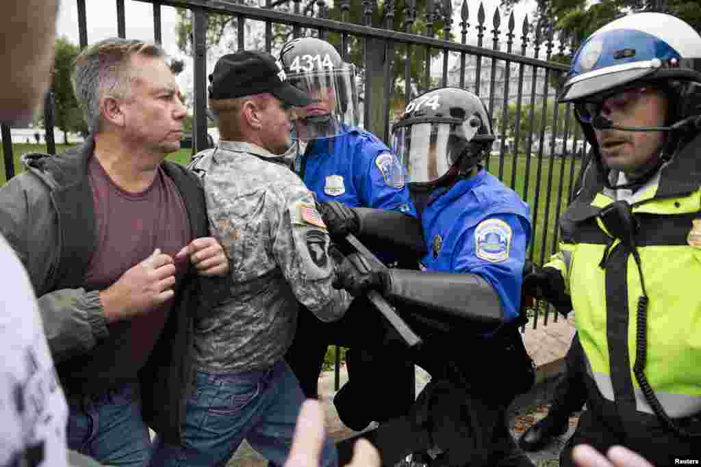Police scuffle with protesters taking part in the "Million Vet March on the Memorials" that drew hundreds of demonstators in front of the White House in Washington, Oct. 13, 2013.