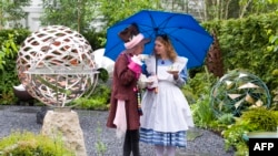 The book "Alice's Adventures in Wonderland" is a favorite around the world. The characters are popular costumes as well! Here, two people dress as "The Hatter" and "Alice" during the Chelsea Flower Show in London, May 2015. (AFP PHOTO)