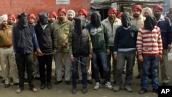 Polisi India bersama 6 anggota gang di negara bagian Punjab (ditutup mukanya) yang menjadi tersangka pelaku perkosaan terbaru terhadap penumpang bis (13/1).