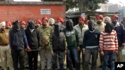 Indian policemen stand with six men, face covered in black sheet, suspected in a gang rape of a bus passenger in Punjab state, India, January 13, 2013. 