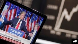 FILE - US President-elected Donald Trump is displayed on a television screen with the curve of the German stock index DAX in background at the stock market in Frankfurt, Germany, Nov. 9, 2016.