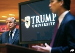 FILE- In this May 23, 2005, file photo, real estate mogul and reality TV star Donald Trump, left, listens as Michael Sexton introduces him at a news conference in New York where he announced the establishment of Trump University.
