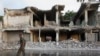 A Somali soldier walks near destroyed buildings, Feb. 27, 2016 after a suicide car bomb on Friday night in Mogadishu, Somalia. 