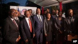Premye Minis Ayisyen an Ariel Henry, mitan, poze pou yon foto an gwoup ak nouvo manm kabine li a nan Potoprens, Ayiti, Mekredi 24 Nov. 2021.