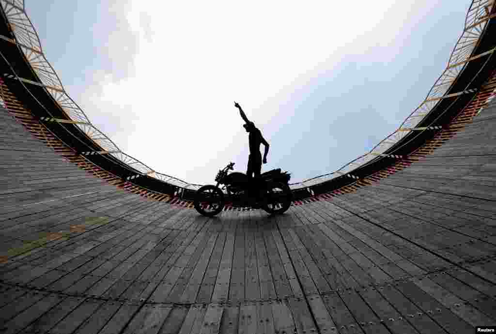 네팔 바크타푸르의&nbsp;&quot;죽음의 벽&quot; 경기장에서 스턴트맨이 오토바이를 시승하고 있다.