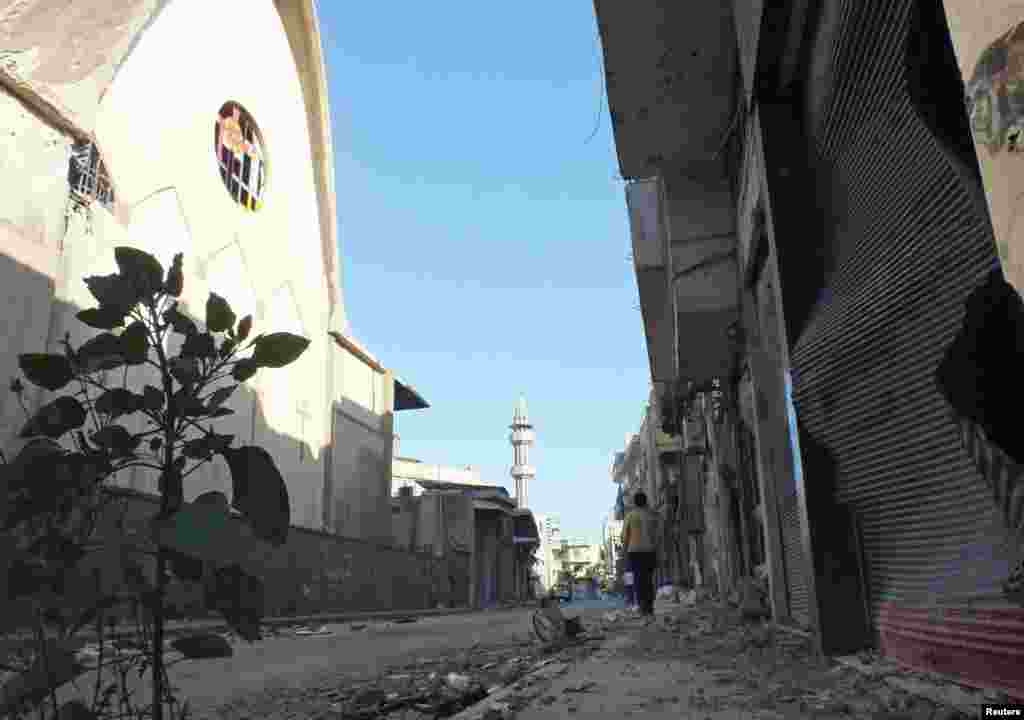 A resident walks on a damaged street in Hamidiyeh, Homs, Syria, July 1, 2012.