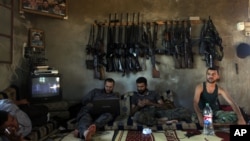 Free Syrian Army fighters sit in a house on the outskirts of Aleppo June 12, 2012. 