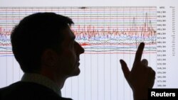 Un sismólogo revisa la gráfica de un movimiento telúrico. Un fuerte sismo sacudió el estado de Maine este martes por la noche.