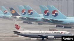한국 인천국제공항 터미널에서 대한항공 여객기가 에어차이나 여객기 옆에서 대기하고 있다.