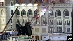 A towering construction crane, center, is seen collapsed over the Grand Mosque, in Mecca, Saudi Arabia, early Saturday morning, Sept. 12, 2015. 