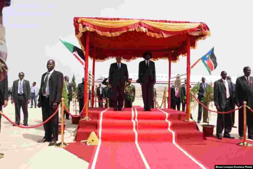 The presidents of Sudan and South Sudan stand to attention, side-by-side, as the national anthems of their countries play at Juba airport on Friday, April 12, 2013 at the start of the first visit by Sudanese President Omar al Bashir to South Sudan.