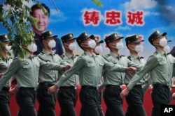 中国武警士兵列队走过宣传习近平领导的宣传画。（2020年5月25日）