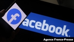 Dalam foto ilustrasi yang diambil di Los Angeles, AS, pada 12 Agustus 2021 ini tampak logo media sosial Facebook terpampang pada sebuah smartphone yang berada di depan sebuah layar komputer. (Foto: AFP/Chris Delmas)