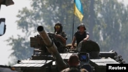 Ukrainian soldiers look out from a tank at a position some 40 miles from the eastern Ukrainian city of Donetsk, July 10, 2014.