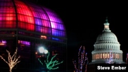The dome of the US Botanic Garden, specially lighted for the Holiday Season, and the dome of the close-by US Capitol.