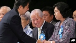 아베 신조 일본 총리(왼쪽)가 지난해 9월 일본의 납북자 피해 가족들과 만나, 문제 해결을 위한 정부의 노력을 약속했다. (자료사진)