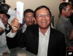 FILE - Opposition Cambodia National Rescue Party President Kem Sokha shows off his ballot before voting in local elections in Chak Angre Leu on the outskirts of Phnom Penh, Cambodia, June 4, 2017.