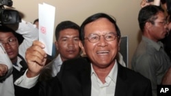 FILE - Opposition Cambodia National Rescue Party President Kem Sokha shows off his ballot before voting in local elections in Chak Angre Leu on the outskirts of Phnom Penh, Cambodia, June 4, 2017. 