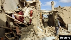 FILE - An Afghan man inspects a house destroyed during an air strike called in to protect Afghan and U.S. forces during a raid on suspected Taliban militants, in Kunduz, Afghanistan, Nov. 4, 2016. 