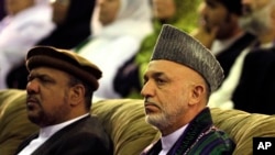 Afghan President Hamid Karzai, right, listens to speeches of delegates with his first vice President Qasim Fahim during the last hours of a three days conference of Peace Jirga in Kabul, Afghanistan, Friday, June 4, 2010. (AP Photo/Musadeq Sadeq)