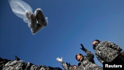 Former North Korean defectors who were soldiers when they lived in North Korea release a balloon containing $1 banknotes, radios, CD and leaflets denouncing the North Korean regime towards the north near the demilitarized zone, which separates the two Koreas, in Paju, north of Seoul, Jan. 15, 2014. 